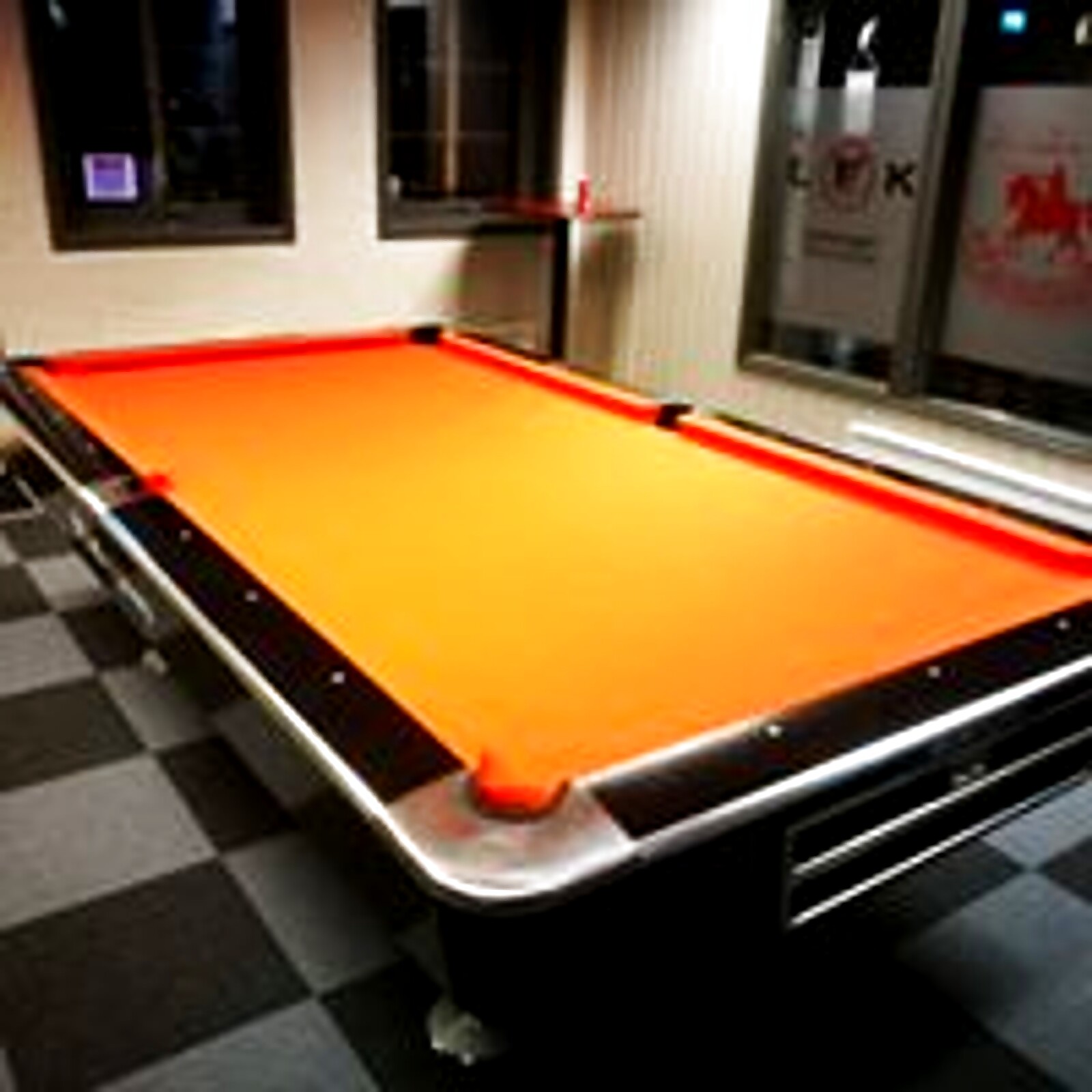 Biljardbord med oransje filt i den lyse, varme stua hos Levanger Bowling